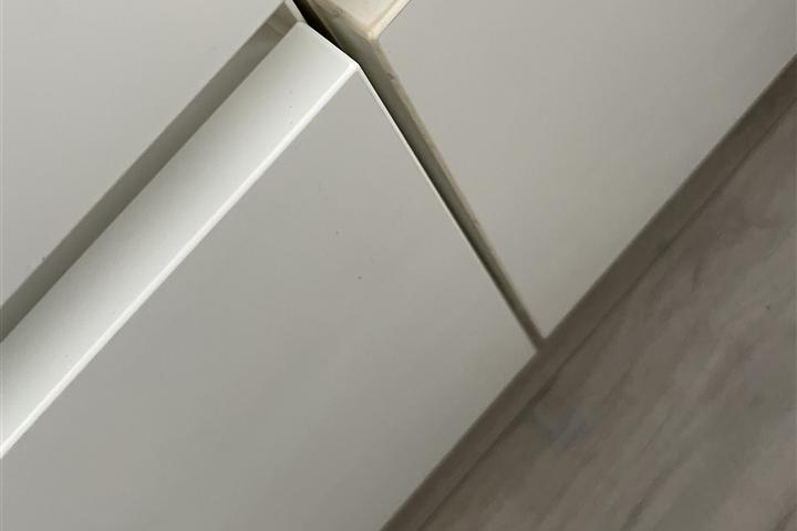 Hoogglans folie die aan de rand van een keukenfront loslaat